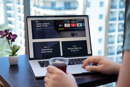 Alanya, Turkey - April 10, 2020: Man hand table backgrounds MacOS Catalina on screen MacBook Pro 16 with Apple TV + app provides streaming movies and show.のeditorial素材