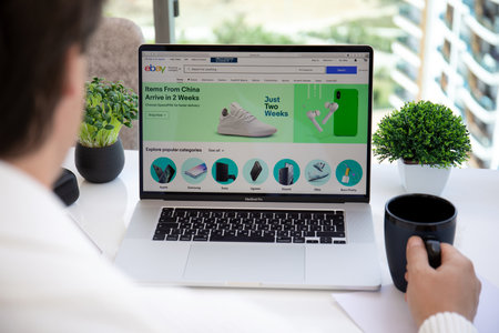 Alanya, Turkey - May 15, 2020: Man hand on Macbook Pro 16 in the table with Internet shopping service Ebay on the screen. Macbook was created and developed by the Apple inc.のeditorial素材