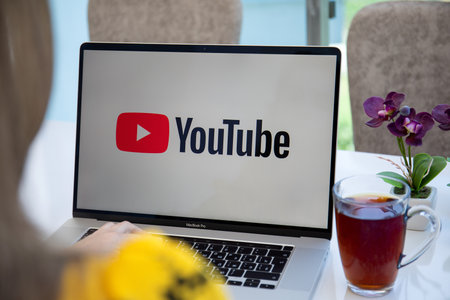 Alanya, Turkey - June 6, 2020: Woman hand Apple Macbook Pro 16 with App YouTube provides streaming media and video on the screen laptop.のeditorial素材