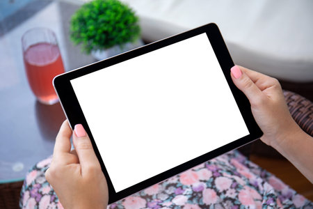 female hands holding computer tablet with isolated screen over table in cafe