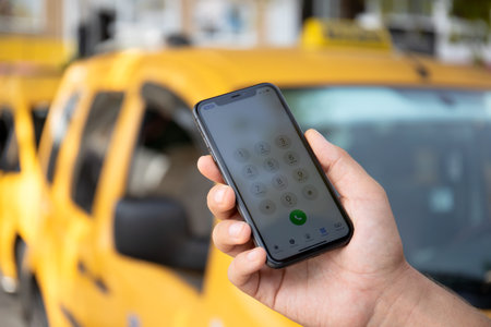 Alanya, Turkey - October 8, 2020: Man hand holding Apple iPhone 11 with call Taxi on the screen. Apple iPhone 11was created and developed by the Apple inc.のeditorial素材