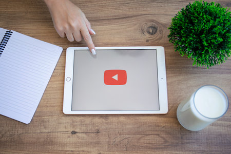 Alanya, Turkey - September 10, 2020: Woman hand touch screen Apple iPad 7 Gold with application video service You Tube on the screen.のeditorial素材