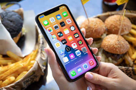 Alanya, Turkey - October 13, 2020: Woman hand holding iPhone 11 with home screen IOS 14 on the screen. iPhone 11 was created and developed by the Apple inc.のeditorial素材