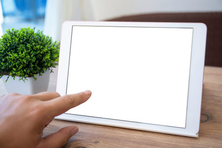 male hand touching isolated screen computer tablet on background of room in house