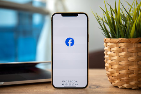 Alanya, Turkey - February 25, 2021: iPhone 12 Pro Max Gold with social networking service messenger Facebook on the screen in the table.のeditorial素材