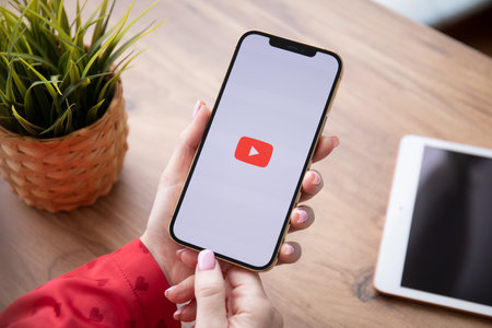 Alanya, Turkey - February 25, 2021: Woman hand holding Apple iPhone 12 Pro Max Gold with App YouTube provides streaming media and video on the screen.のeditorial素材