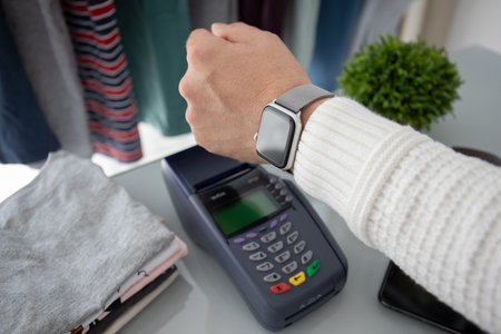 Anapa, Russia - August 12, 2019: Man hand holding Apple Watch with Apple Pay on the screen and Pay POS terminal.のeditorial素材