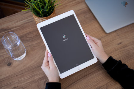 Alanya, Turkey - December 16, 2020: Woman hands holding iPad Gold with streaming service media and video TikTok on the screen.のeditorial素材