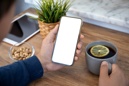 male hands holding phone with isolated screen over table in cafe
