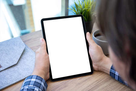 male hands hold computer tablet upright with isolated screen over table in officeの写真素材