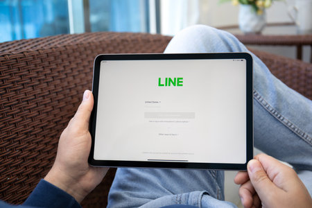 Alanya, Turkey - May 12, 2021: Man hand holding iPad Air Space Gray with social networking service Line on the screen.のeditorial素材