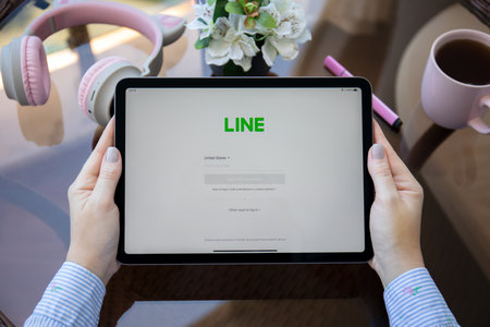 Alanya, Turkey - May 27, 2021: Woman hand holding iPad Air Space Gray with social networking service Line on the screen.のeditorial素材