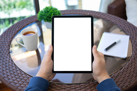 male hands holding computer tablet with isolated screen background of table in cafe