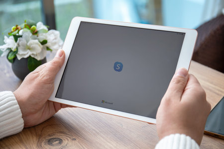 Alanya, Turkey - March 31, 2021: Man hand holding iPad Air Space Gray with app calling Skype on the...