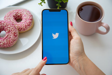 Alanya, Turkey - August 6 2021: Woman hand holding iPhone 12 Pro Max Gold with social networking service Twitter on the screen.のeditorial素材