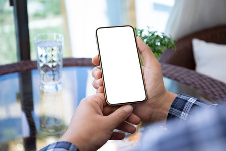 male hands holding phone with isolated screen over table in cafe