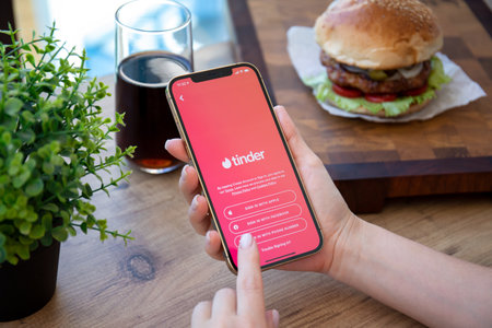 Alanya, Turkey - September 23, 2021: Woman hands holding iPhone 12 Pro Max Gold with online Internet network service Tinder on the screen.のeditorial素材