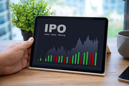 male hands holding computer tablet with IPO stocks purchase app on screen in cafe