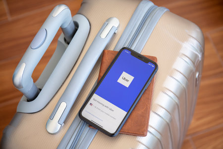 Alanya, Turkey - June 12, 2020: Luggage Delsey and iPhone 11 with application Taxi Uber on the screen.のeditorial素材
