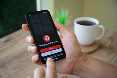 Alanya, Turkey - September 29, 2022: Man hand holding Apple iPhone 14 with app Pinterest in the screen. iPhone 14 was created and developed by the Apple inc.のeditorial素材