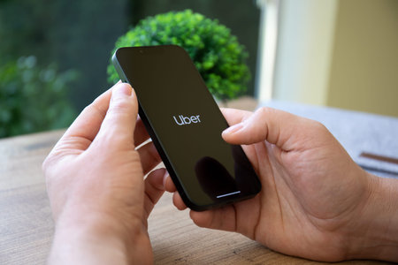 Alanya, Turkey - February 23, 2022: Man hand holding iPhone 13 Pro Graphite with application Taxi...