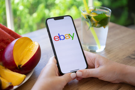 Alanya, Turkey - July 22, 2022: Woman hands holding iPhone 13 Pro Graphite with online Internet shopping service eBay on the screen.のeditorial素材