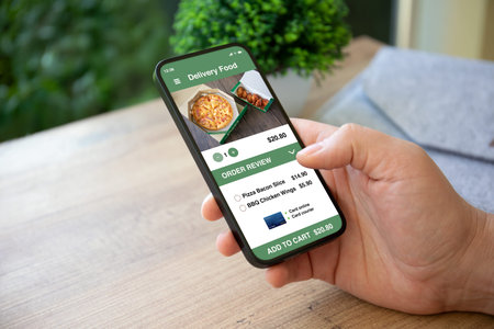 male hand holding phone with food delivery app in cafe