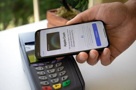 Alanya, Turkey - May 24 2023 : Man hand holding iPhone 14 with Apple Pay Cash on the screen and pay pass online terminal.のeditorial素材