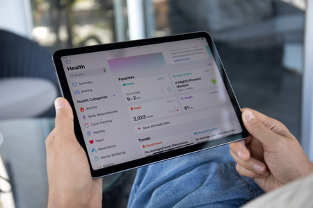 Alanya, Turkey - September 20, 2023: Man hand with Apple iPad Air with app Activity Health on the screen.のeditorial素材