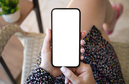 female hands hold phone with isolated screen background of summer cafeの写真素材