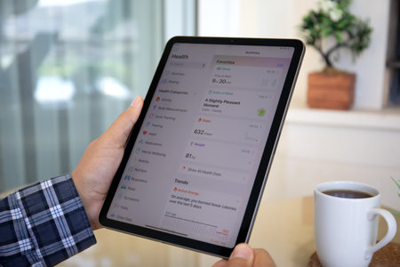 Alanya, Turkey - September 19, 2023: Man hand with Apple iPad Air with app Activity Health on the screen.のeditorial素材