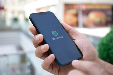 Alanya, Turkey - September 26, 2023: Man with iPhone 14 with messenger WhatsApp on the screen.のeditorial素材