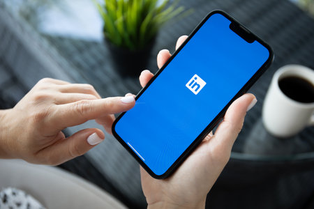 Alanya, Turkey - October 5, 2023: Woman hand holding Apple iPhone 14 with app LinkedIn on the screen.のeditorial素材