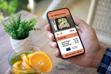 male hand holding phone with food delivery app in cafe
