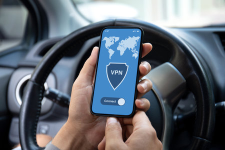 male hand hold phone with app vpn on screen background of car steering wheelの写真素材