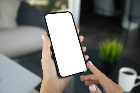 female hands hold phone with isolated screen background cafe in officeの写真素材