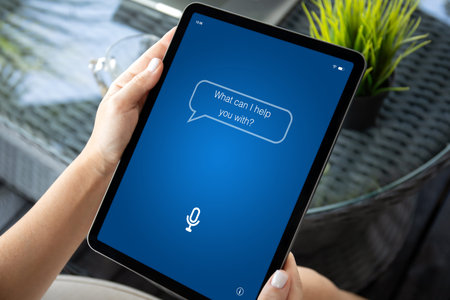 female hands hold computer tablet with app personal assistant on screen over table in office