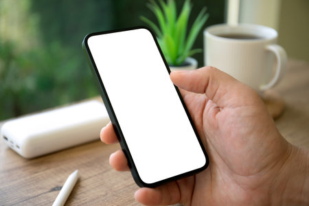 male hands holding phone with isolated screen background cafe in the officeの写真素材