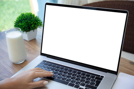 female hand on keyboard laptop with isolated screen background table in cafe officeの写真素材