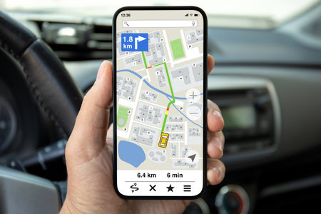 male hands hold phone with navigation application background of steering wheel in carの写真素材