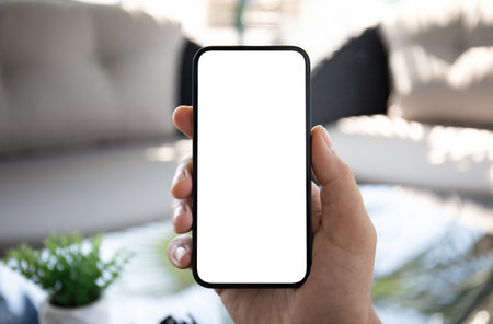 Man hand hold phone with isolated screen background of hotel lobby in cafeの写真素材