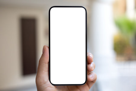 Male hand hold phone with isolated screen background of the street in hotelの写真素材