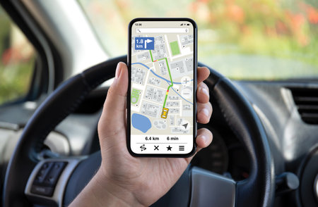 male hands hold phone with navigation application background of steering wheel in carの写真素材