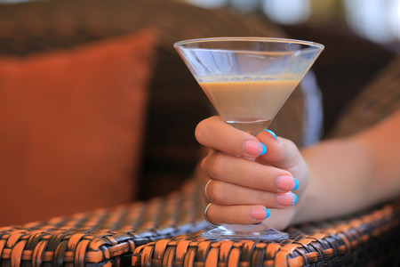 liqueur in a glass in a female handの写真素材