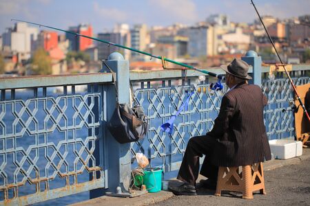 Old fisherman catch fish on the bridge in cityの写真素材