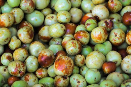 Background of green plums on the marketの写真素材
