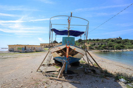 Porto Palermo, Albania - 21 october, 2020: Old broken boat on the beach in the harbor in Porto Palermo, Albaniaのeditorial素材