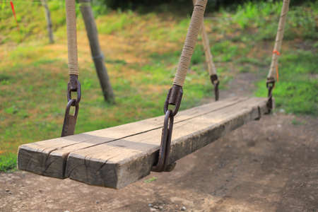 Old wooden swing in the forest in summerの写真素材