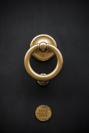 Big yellow knock ring on the dark doorの写真素材