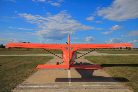 Small private red propeller plane on the runway